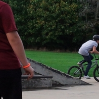Skateboarder stops to watch BMXer go for a trick